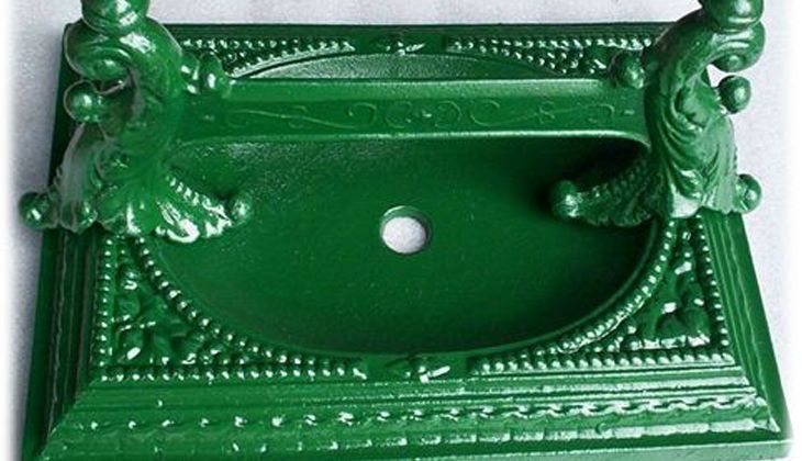 A green sink with a hole in the middle is sitting on a table.