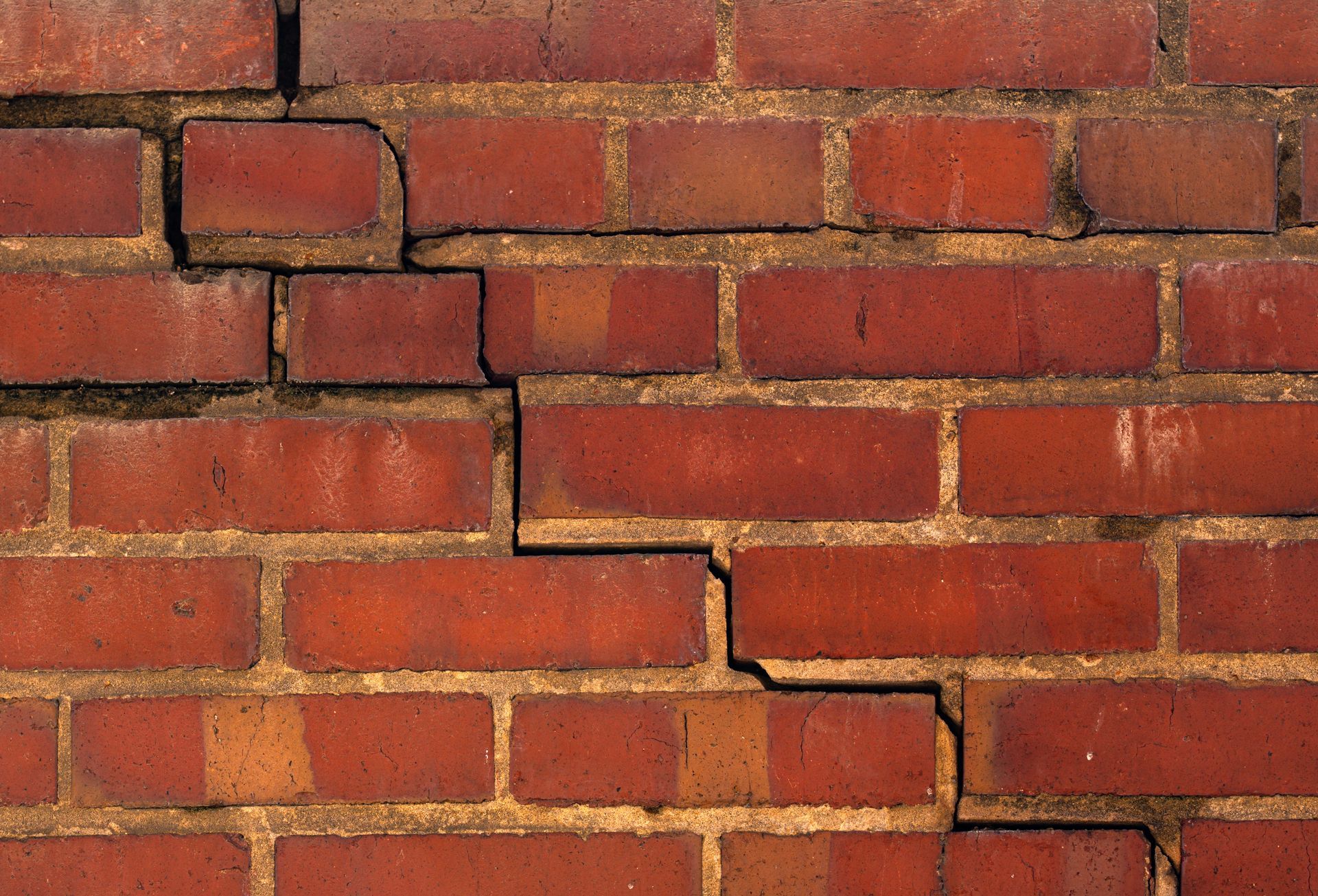 Brick wall cracks needing a professional masonry repair contractor to fix foundation issues.