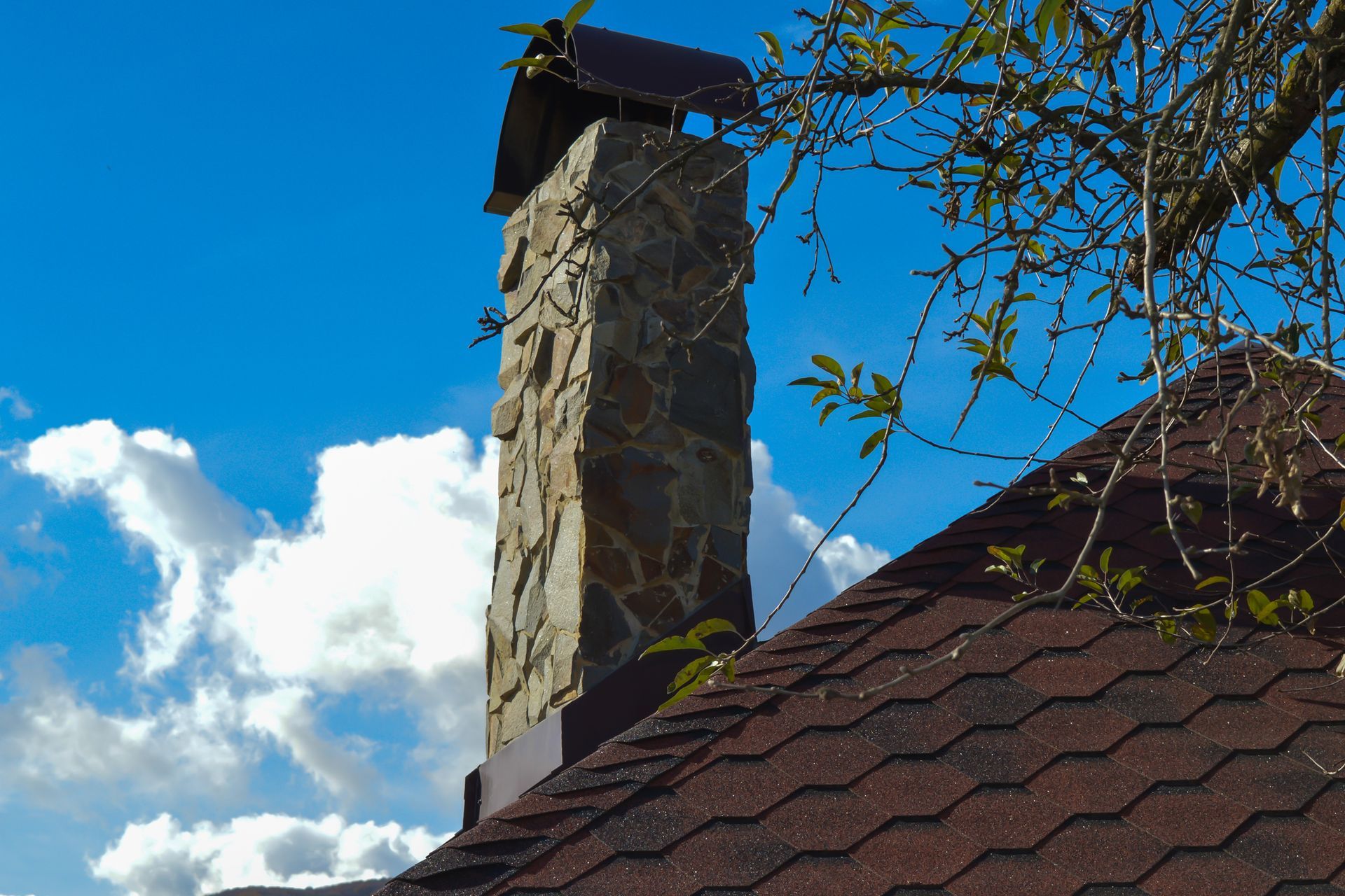Restored stone chimney structure on a residential property.