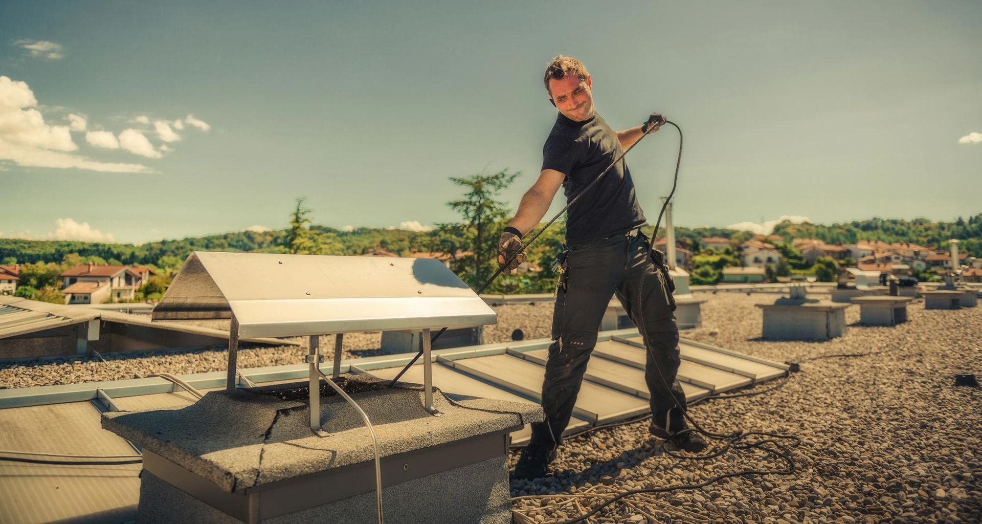 A man cleaning a chimney on a roof, showing safe work by chimney repair companies.