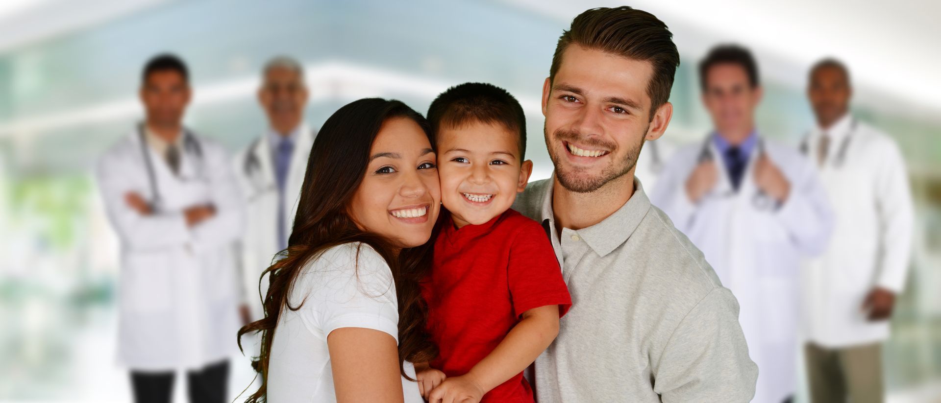 A family is posing for a picture in front of a group of doctors.
