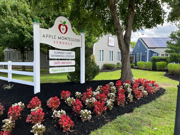 Colorful flower garden with stone edging beside a house and green lawn