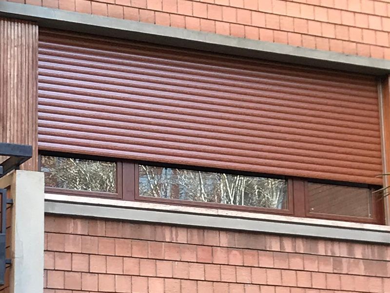 Una finestra con una persiana avvolgibile marrone