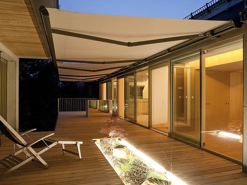 Un ponte con una sedia e un tavolo sotto una tenda da sole.