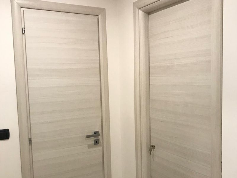 Due porte bianche sono una accanto all'altra in un corridoio.