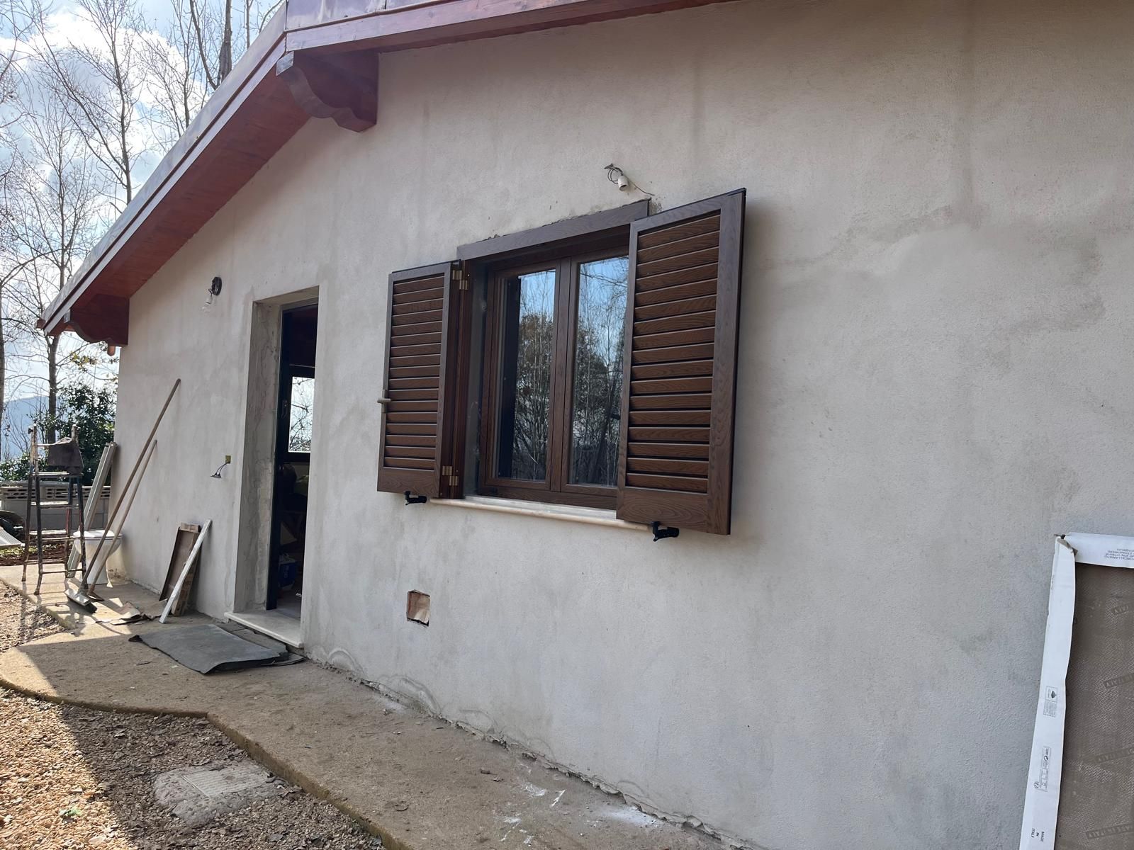 Una casa con una finestra e delle persiane