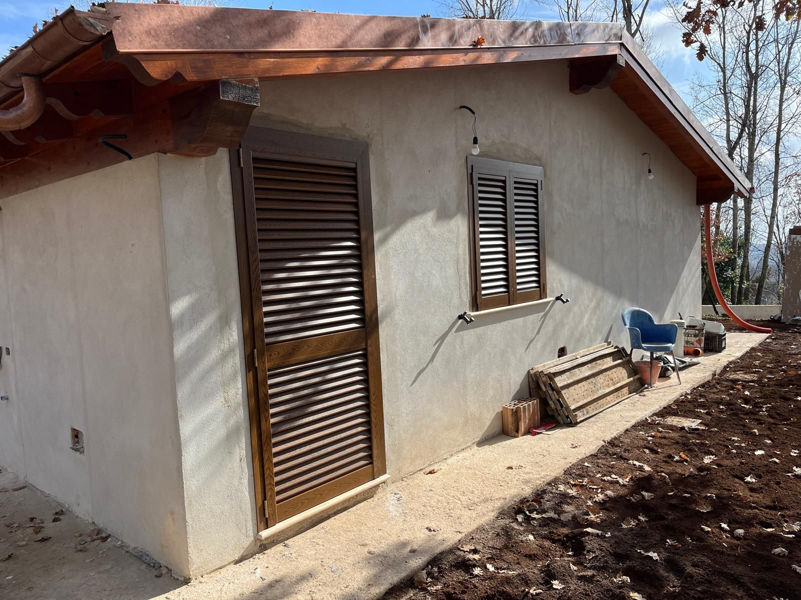 Una piccola casa bianca con le persiane alle finestre