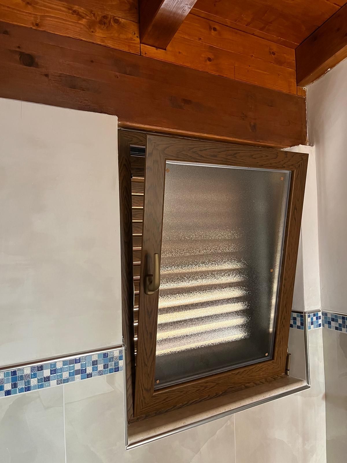 Un bagno con finestra e soffitto in legno.