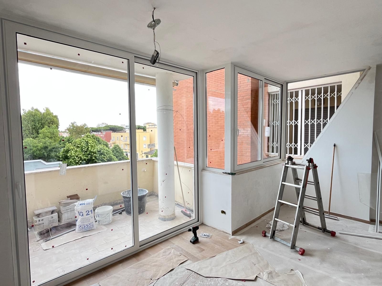 Una stanza con molte finestre e una scala al suo interno.