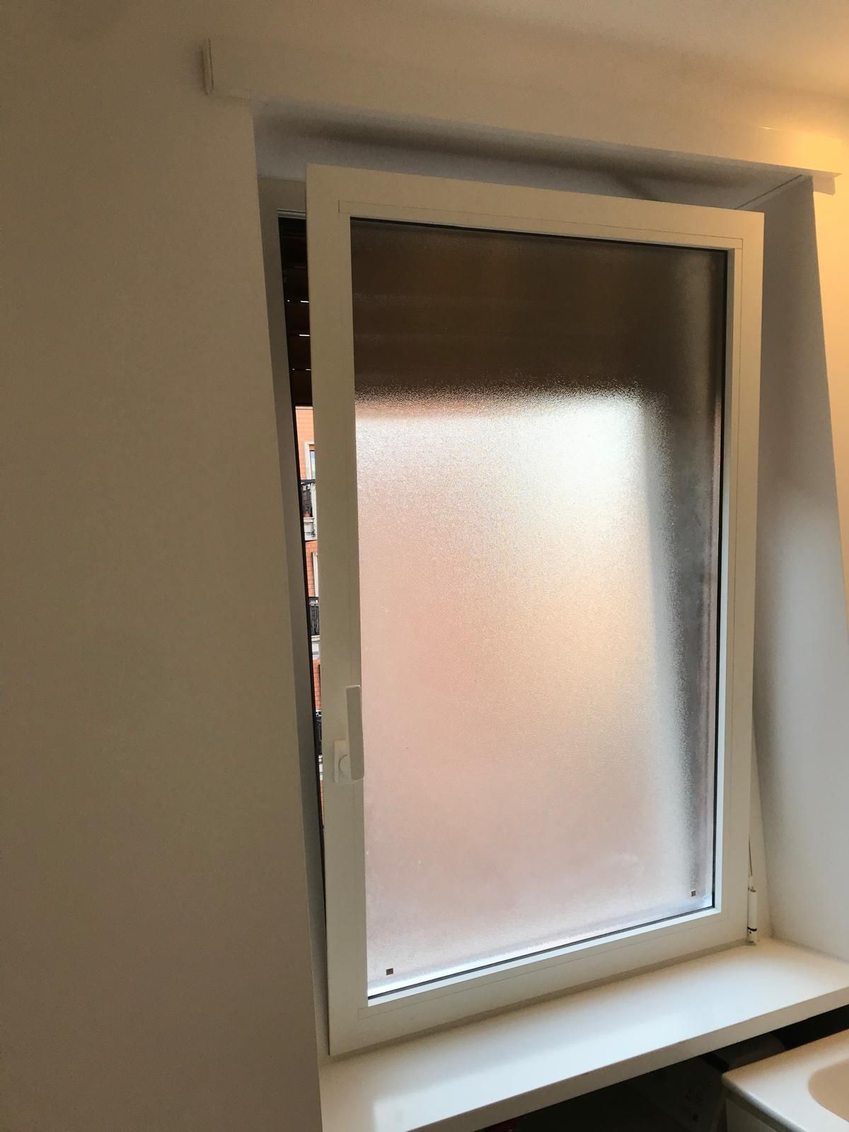 In cucina è aperta una finestra con un vetro smerigliato.