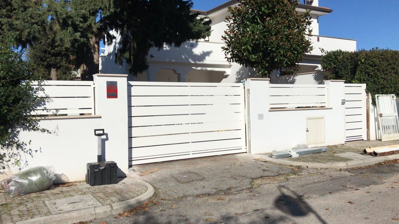 Una casa bianca con una staccionata bianca e un cancello bianco