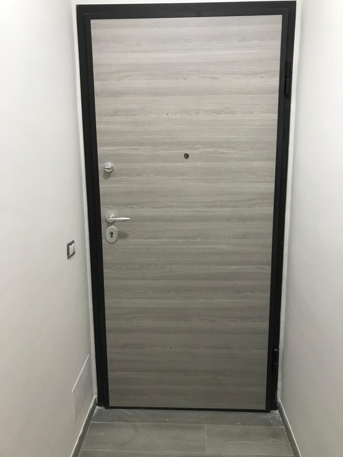 Una porta è posizionata in un corridoio, accanto a un muro.