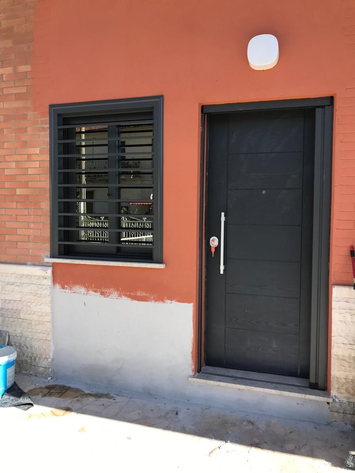 Un edificio di mattoni con una porta nera e una finestra