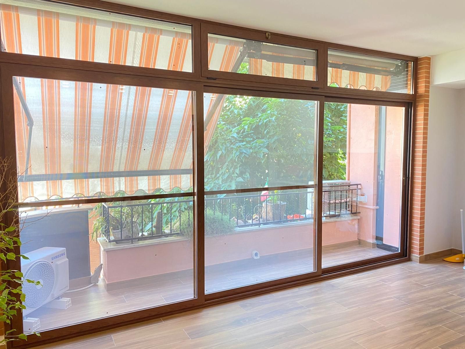 Un soggiorno con porte scorrevoli in vetro che conducono a un balcone.