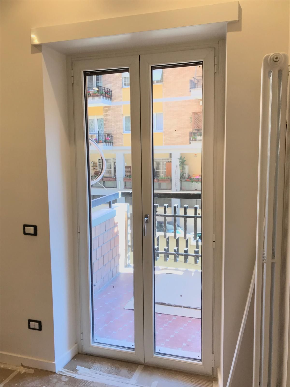 Una porta bianca con vista su un balcone in una stanza.