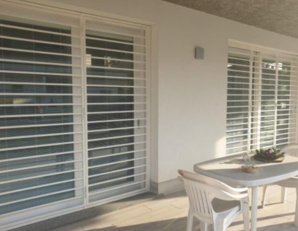 Un tavolo e sedie su un balcone con porte scorrevoli in vetro