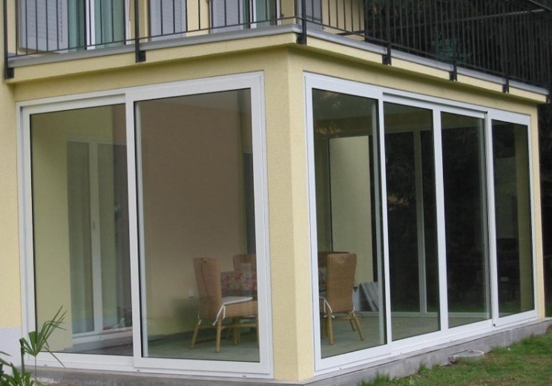 Una casa con molte finestre e un balcone