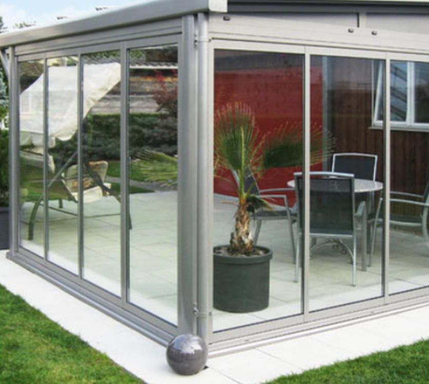 Un patio con tavolo, sedie e una pianta in vaso