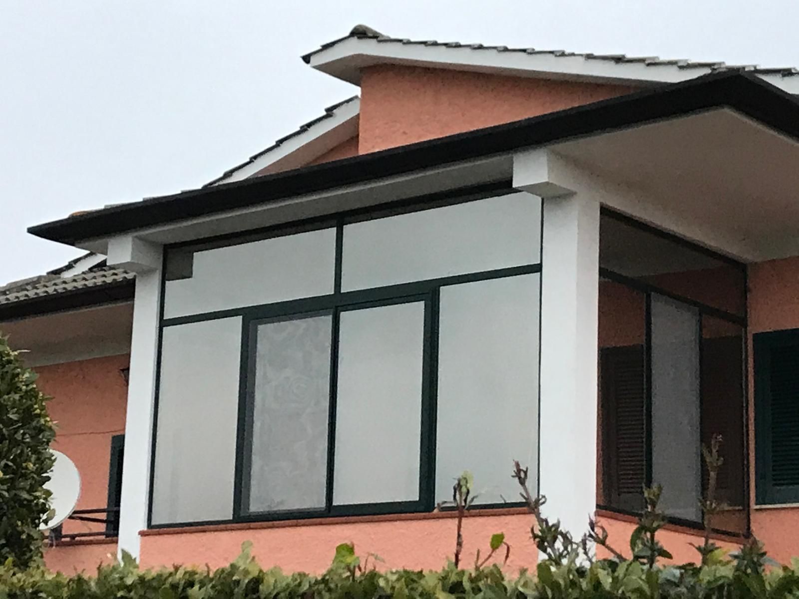 Una casa con molte finestre e una parabola satellitare