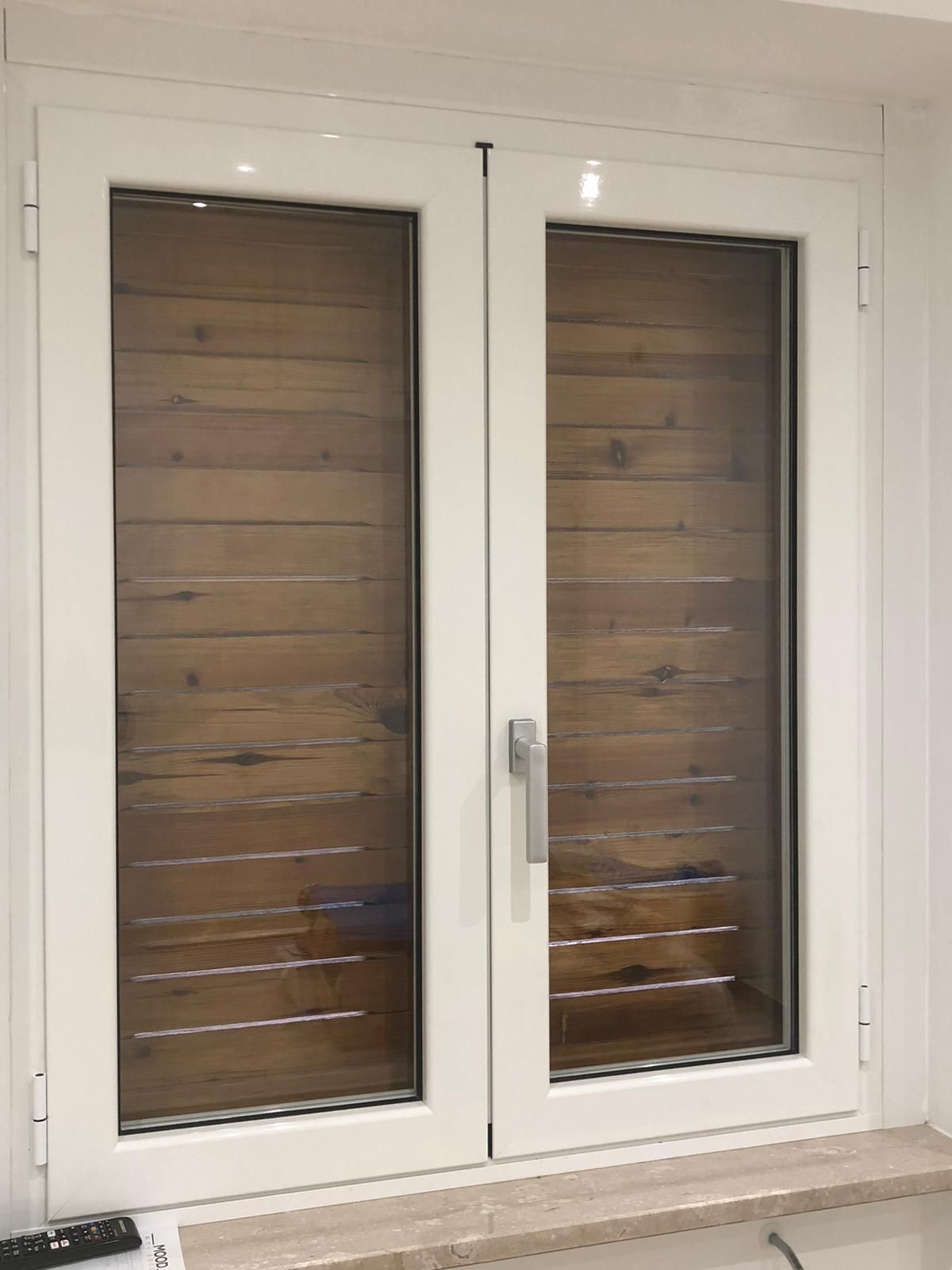 Una finestra bianca con persiane di legno