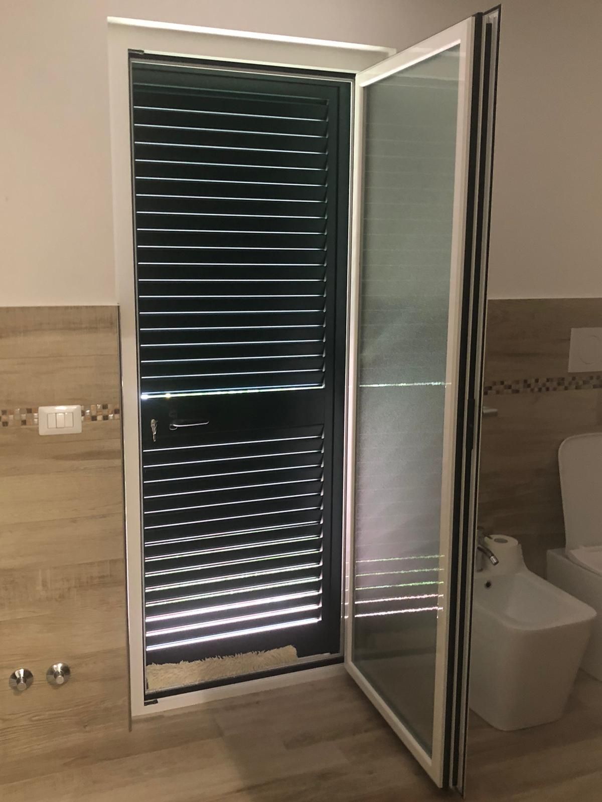 Un bagno con un water e una finestra con le persiane