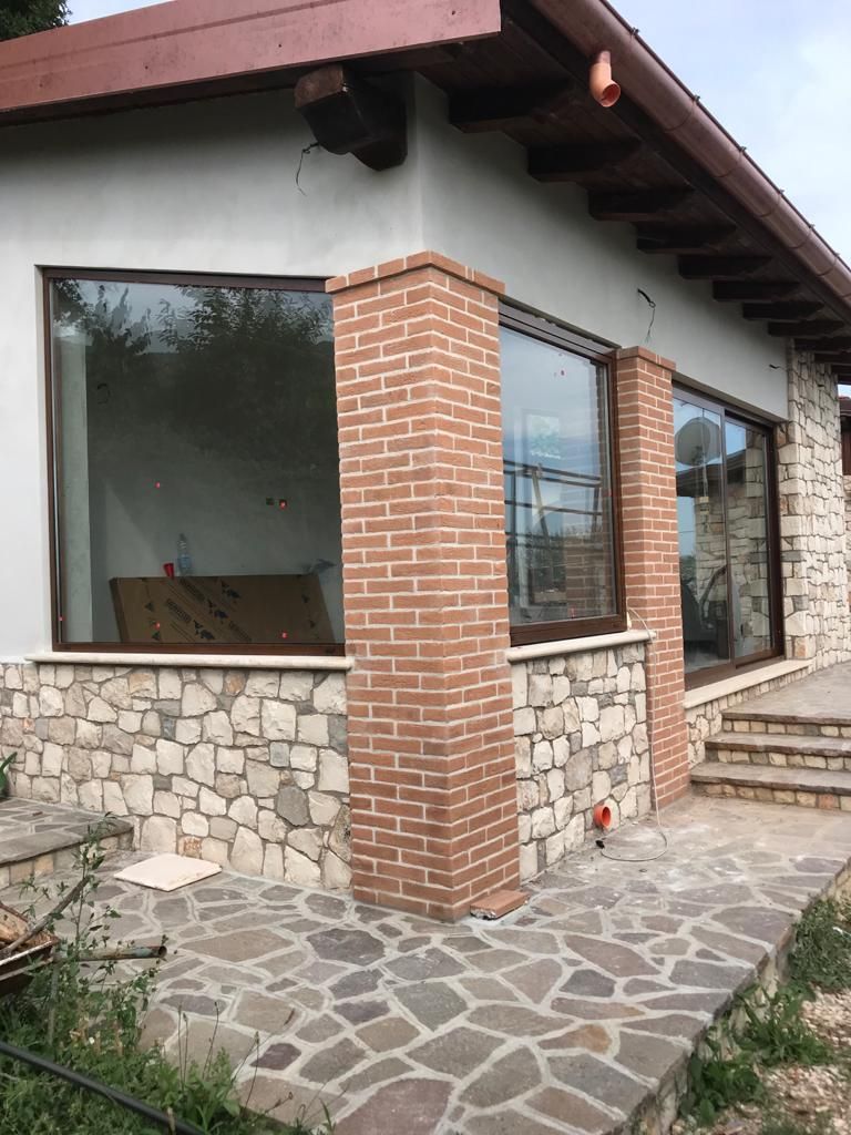 Un edificio in mattoni con un muro in pietra e porte scorrevoli in vetro.