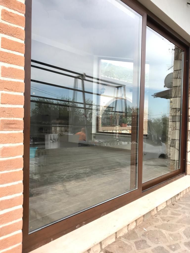 Una grande finestra con una cornice di legno si trova su un muro di mattoni.