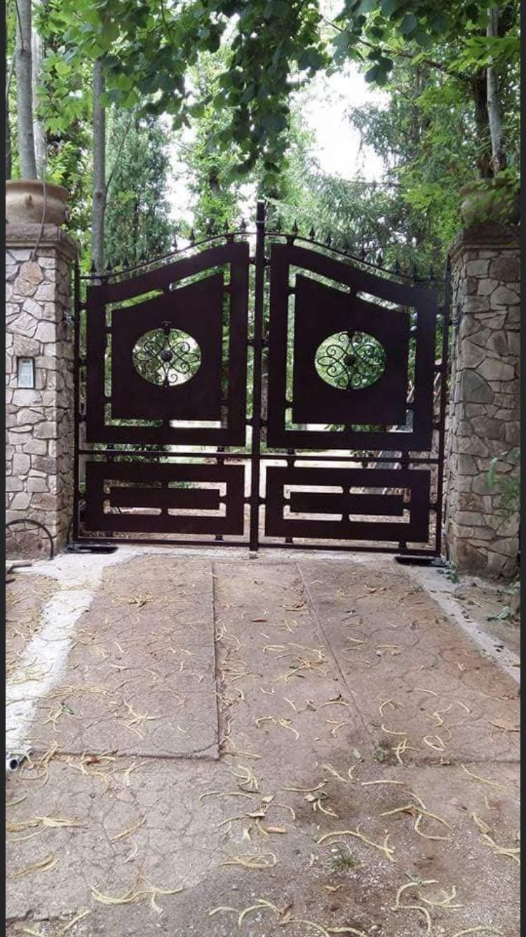 Un cancello con un muro di pietra e alberi sullo sfondo