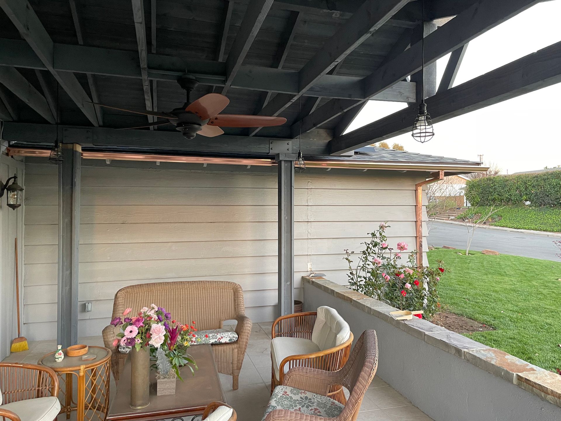 Covered patio with wicker furniture and a ceiling fan.
