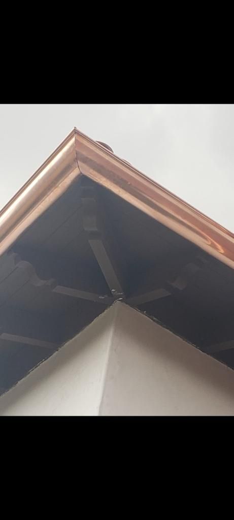 Copper-trimmed roof corner, visible ceiling fan, and white walls.