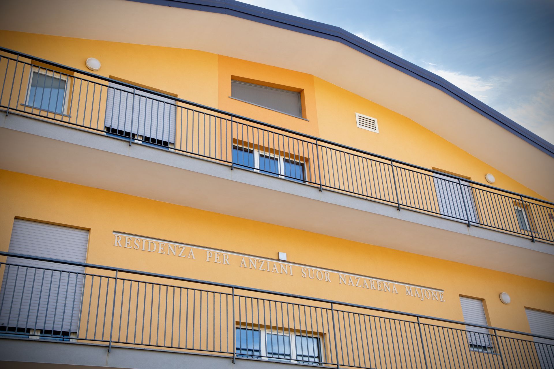 Edificio giallo con balconi e ringhiere scure.