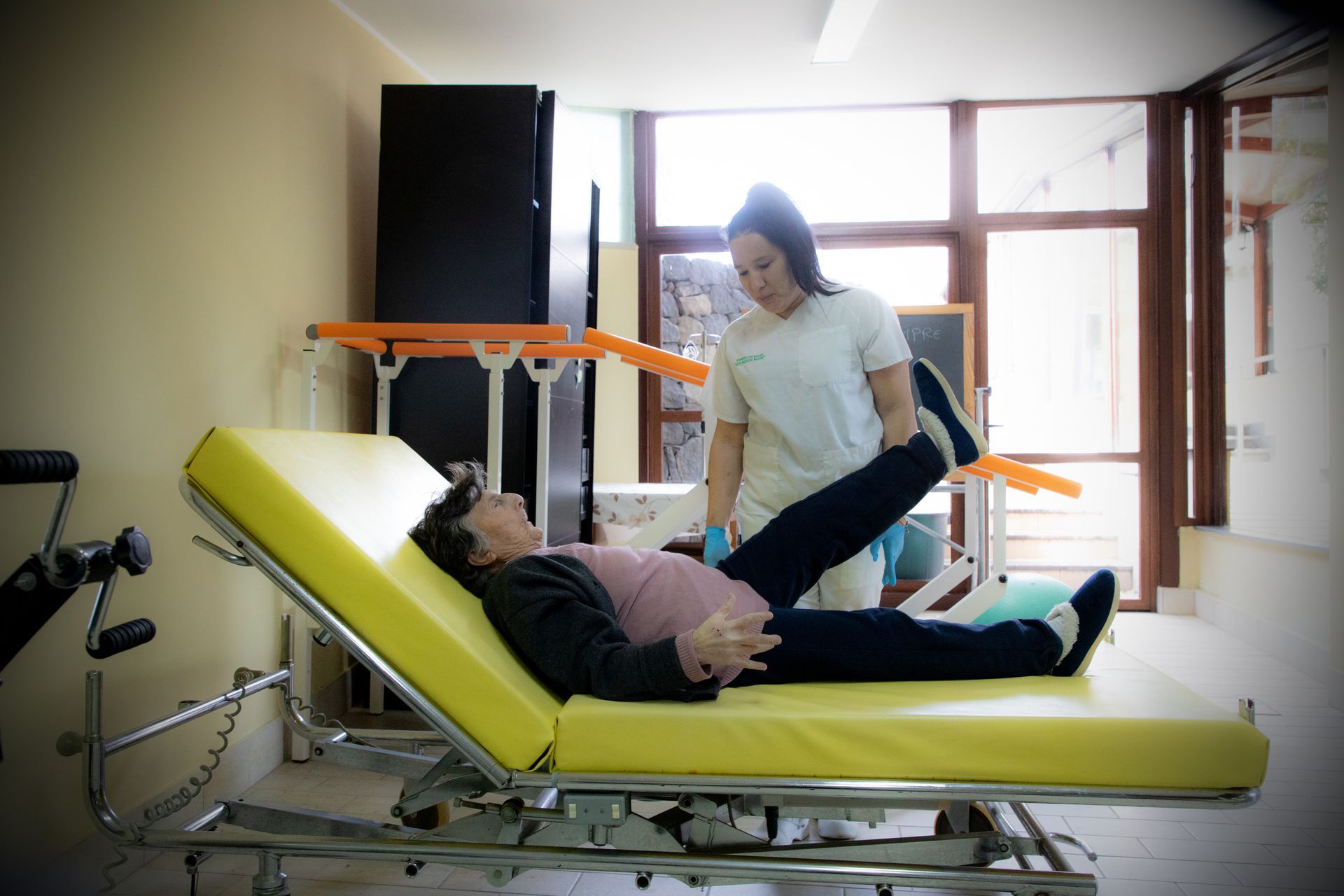 Donna sottoposta a terapia fisica da parte di un operatore sanitario in una sala trattamenti.