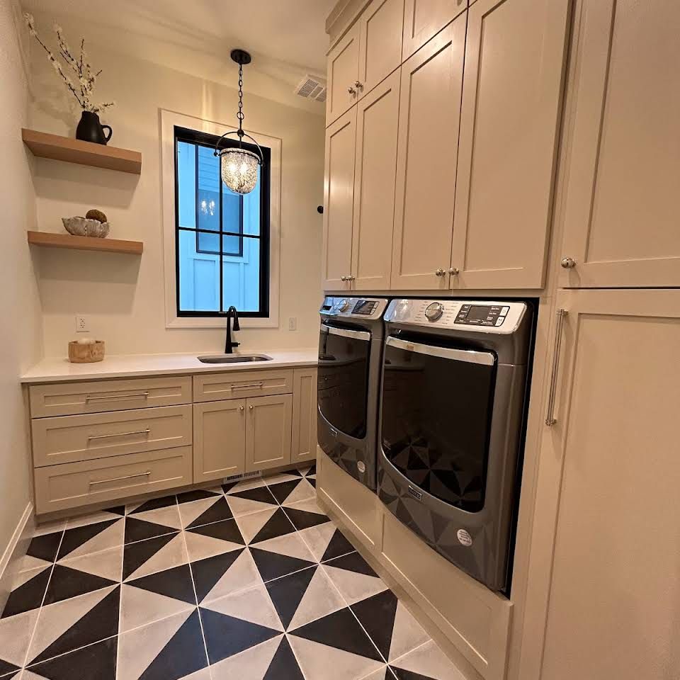 A kitchen with two ovens and a black and white tile floor