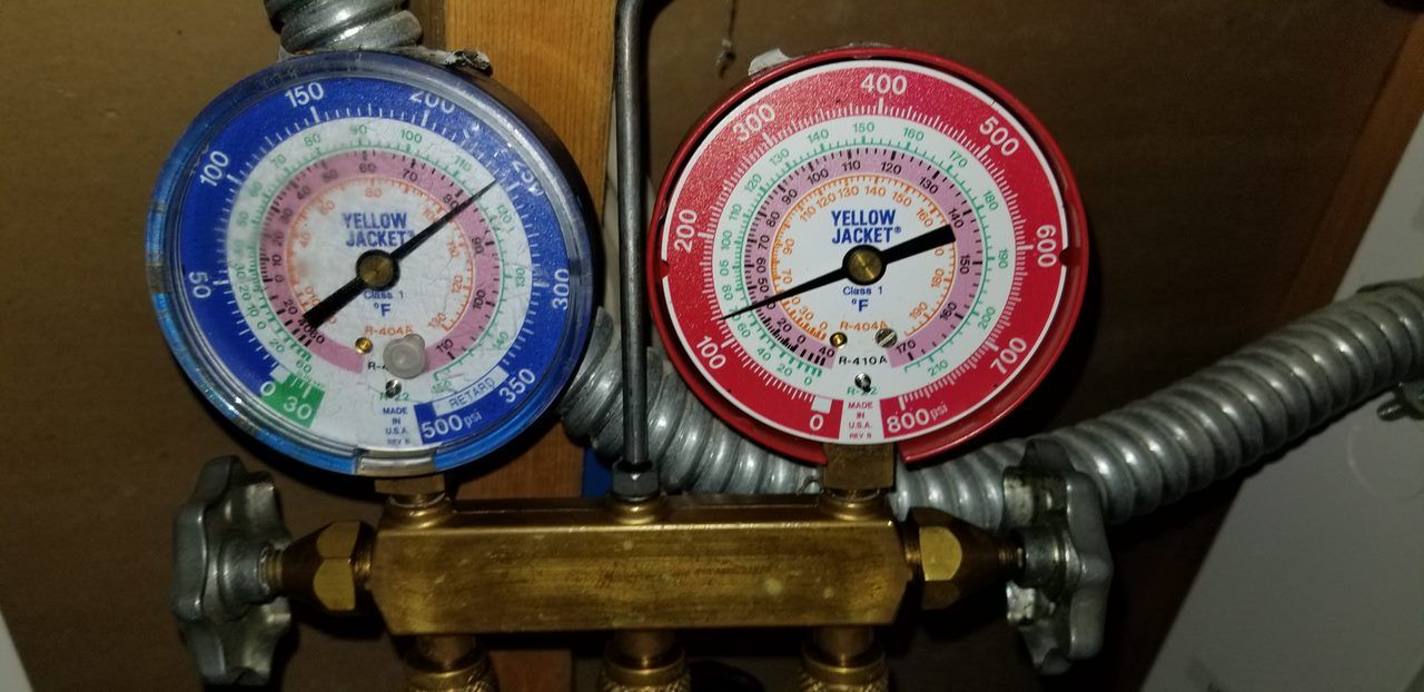 A pair of gauges on a pipe with one that says ' r32 ' on it