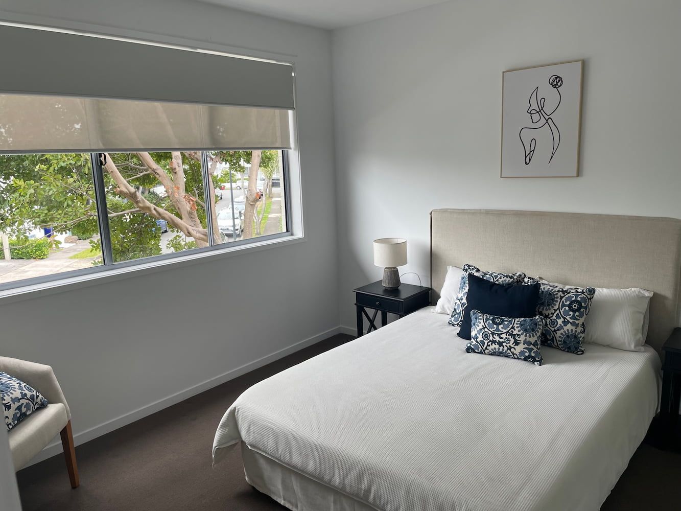 Bedroom With a Bed, Chair, Nightstand and Window — Timeless Blinds And Shutters In Burleigh Heads, QLD