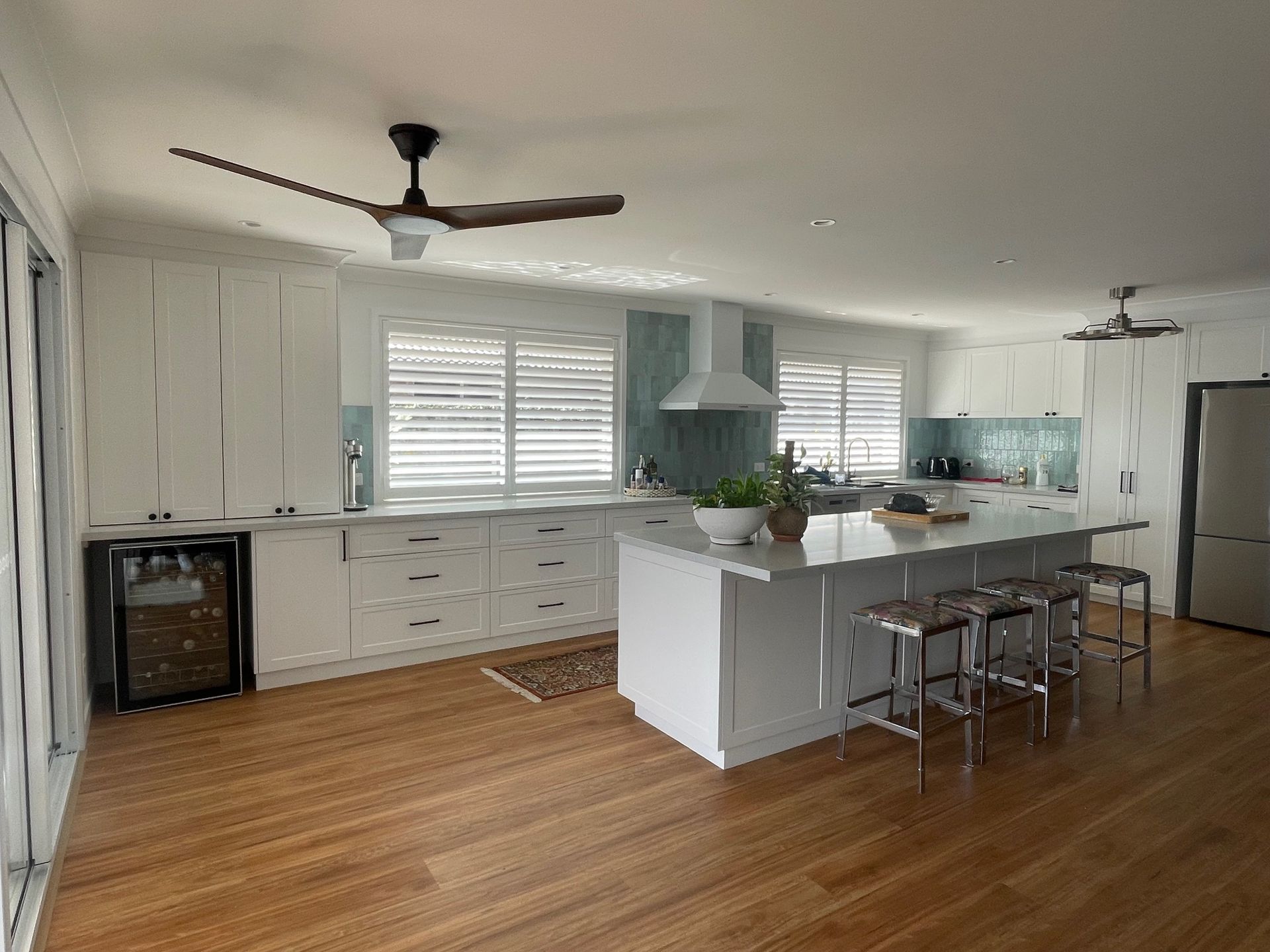 Kitchen With White Cabinets and Wooden Floors — Timeless Blinds And Shutters In Burleigh Heads, QLD