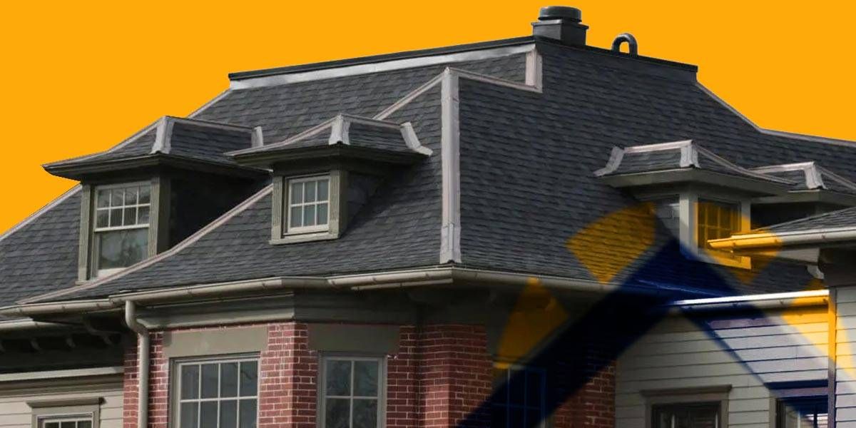 Brick house with a dark gray roof against an orange background.