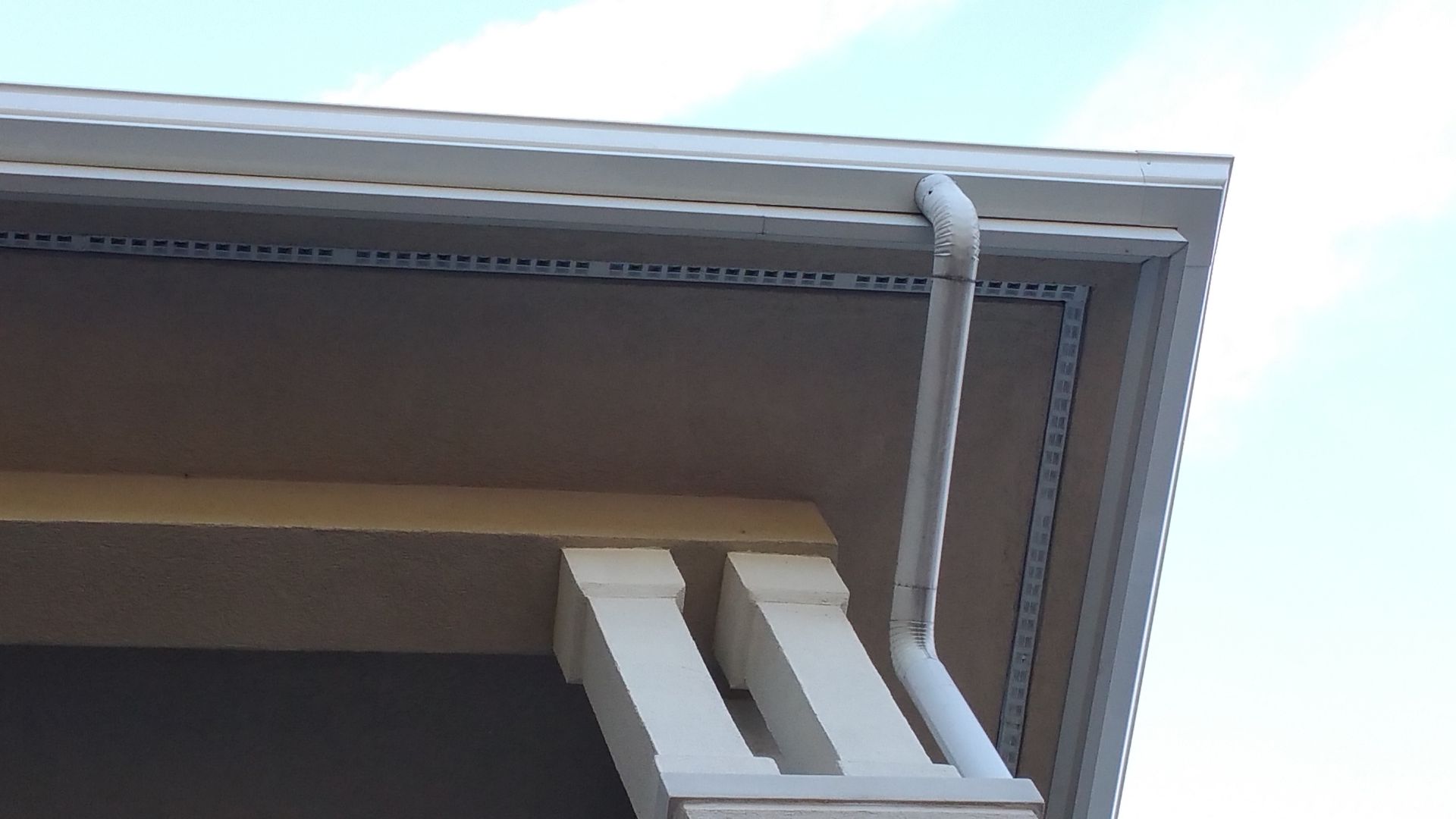 Green metal roof with vertical seams. Trees in the background.