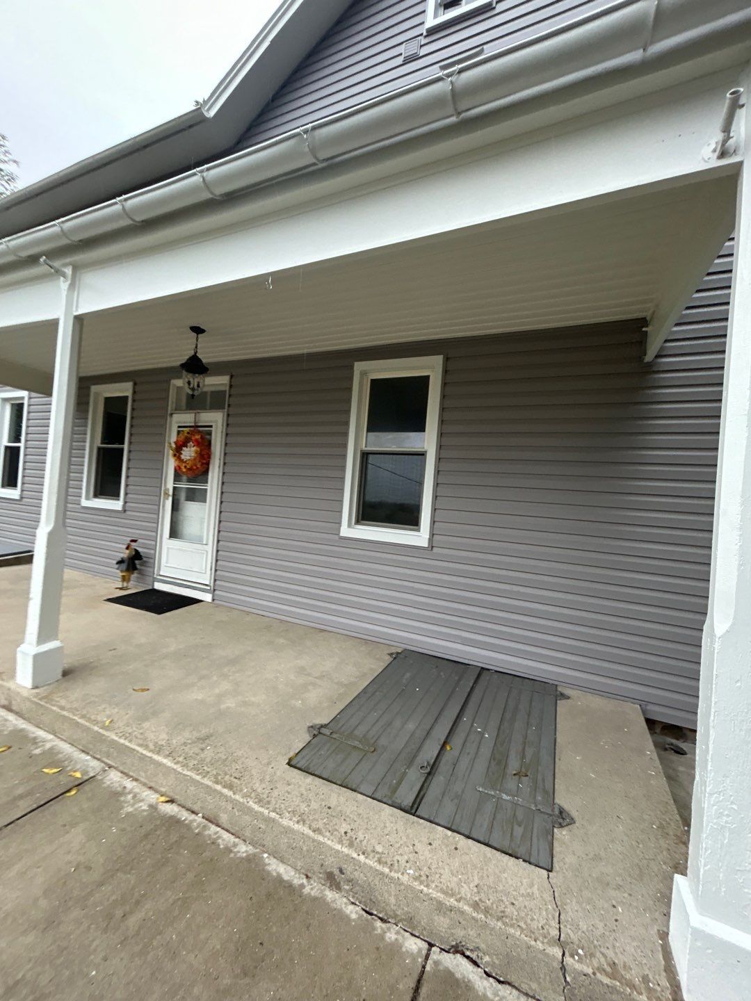 Gray house with covered porch, front door, and windows.