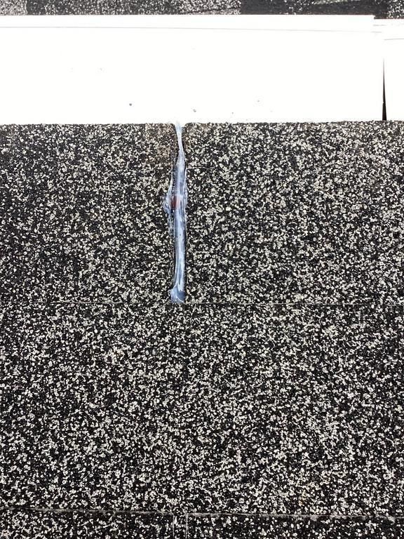 White streaks running down dark speckled surface, possible water leak.