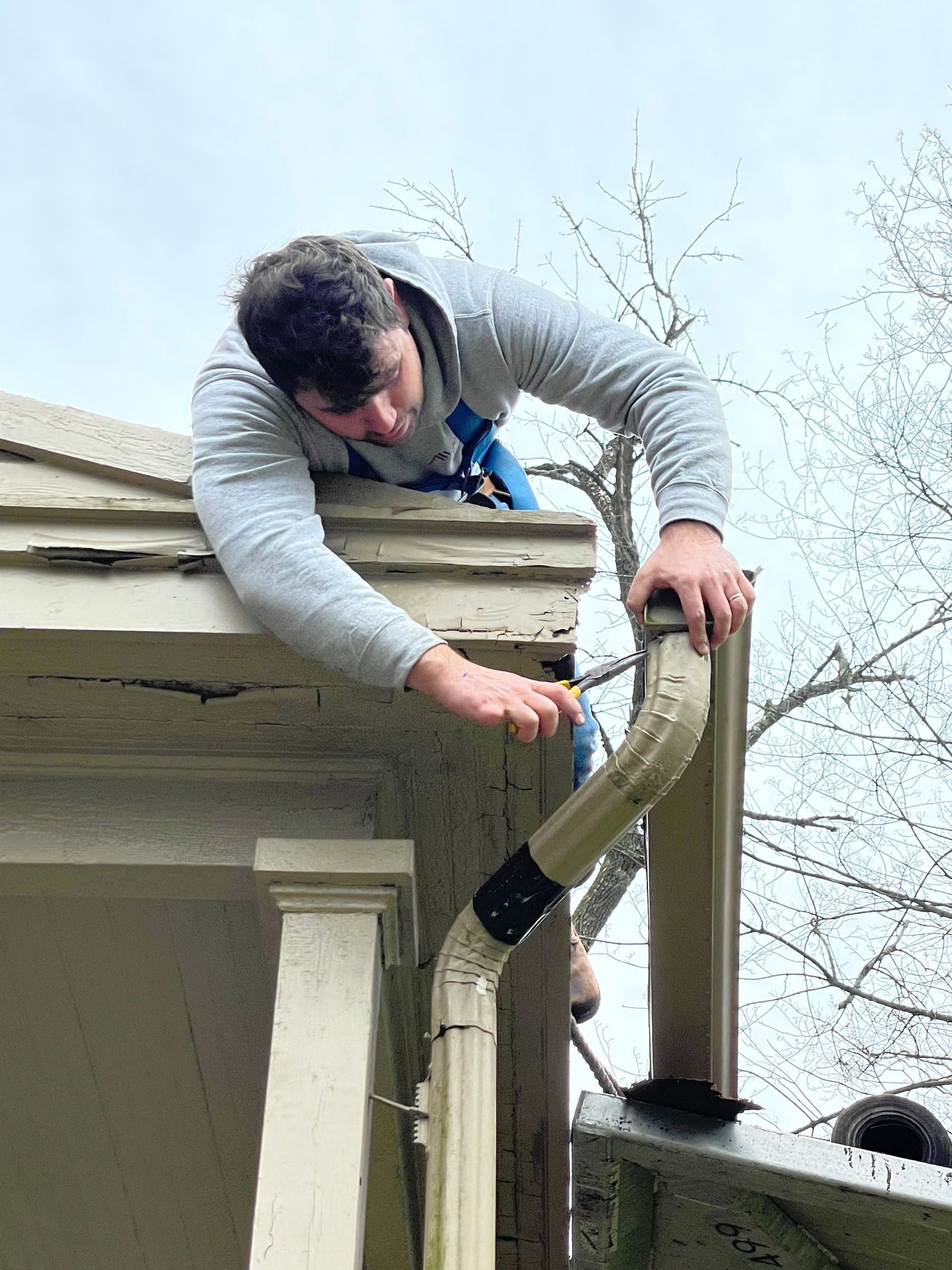 Green metal roof with vertical seams on a building.