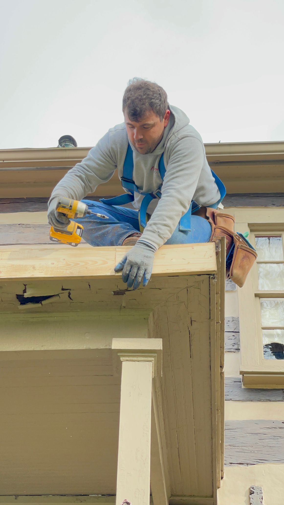 Wooden shingle roof with copper flashing along the angled edge. Beige gutter below.