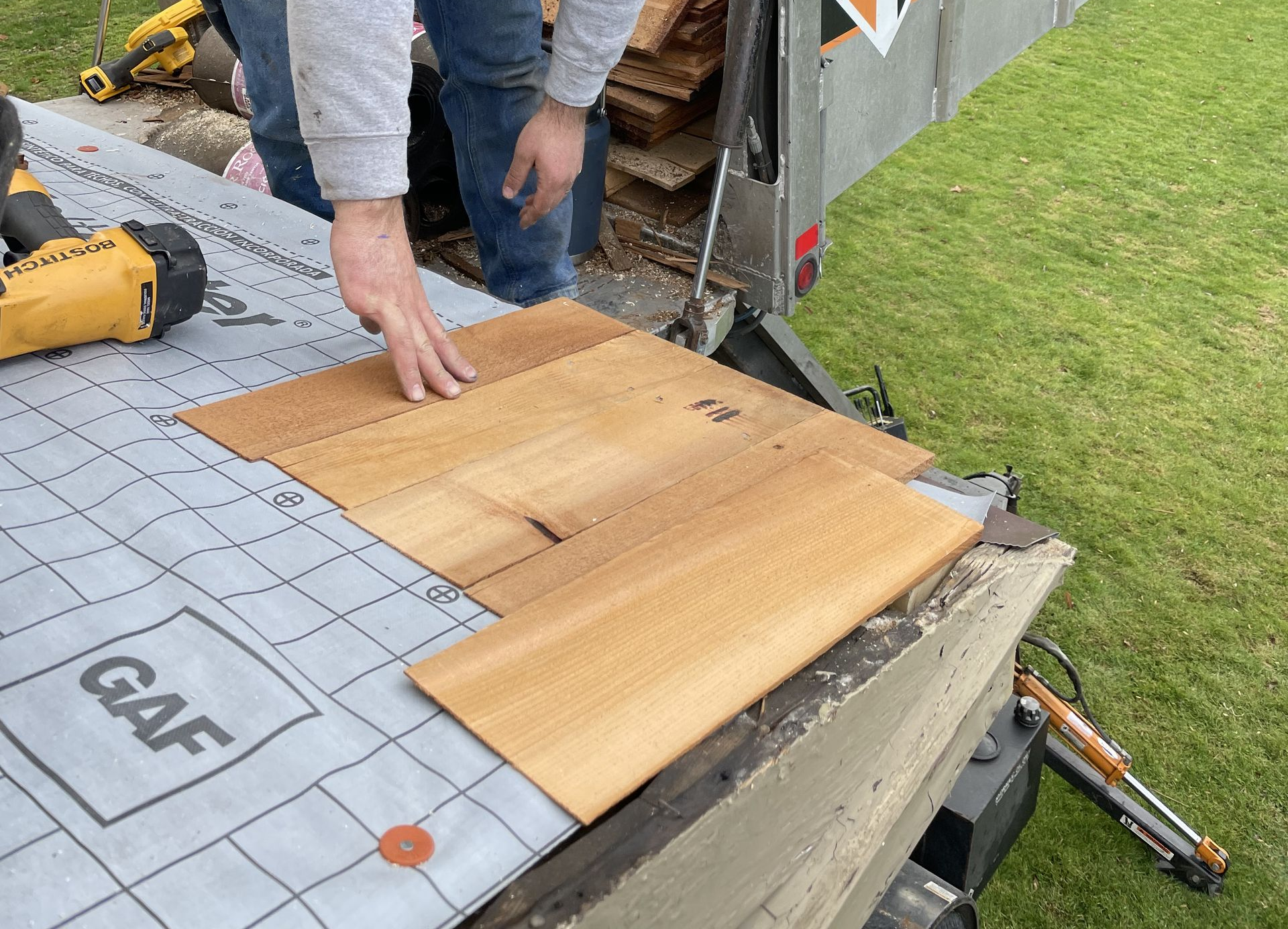 A white house with a porch and attached two-car garage under an overcast sky. A paved driveway curves towards the house.