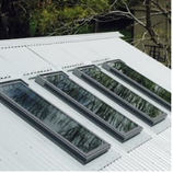 Five rectangular skylights installed on a corrugated metal roof.