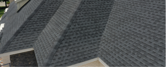 A close-up view of a dark gray shingled roof with multiple angles and valleys.