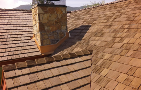 Two-story brick house with gray tiled roof and climbing ivy.