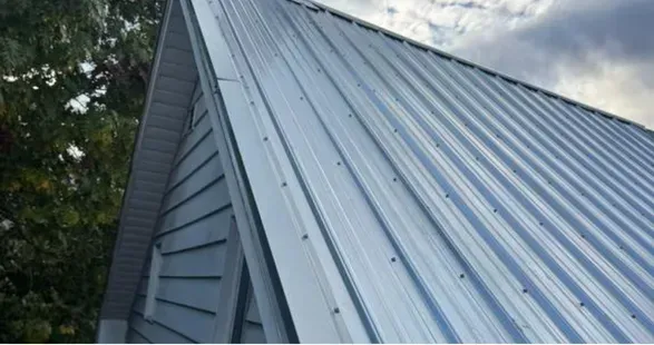 Brick house with gray slate roof, ivy climbing the walls, black-framed windows, and a green awning.