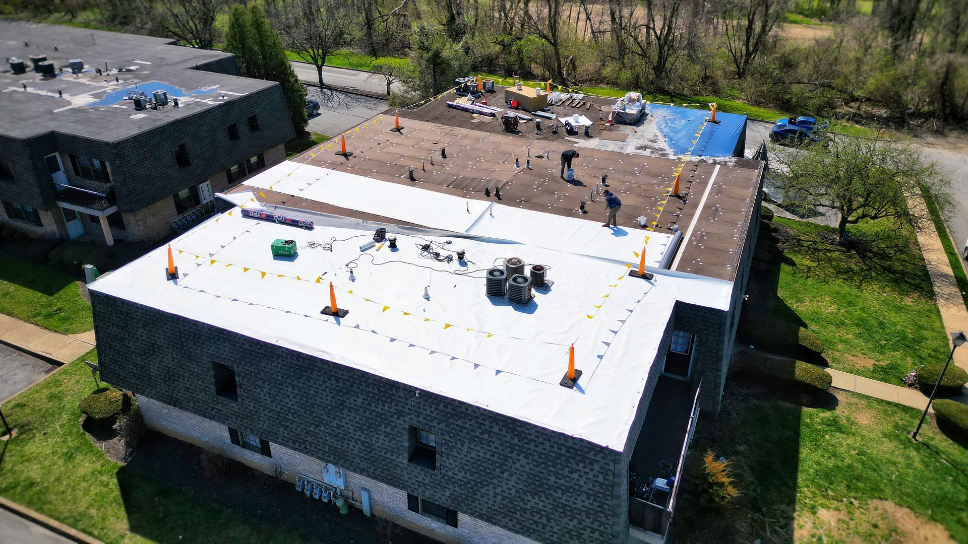 Brick house with a gray roof and a driveway on a sunny day.
