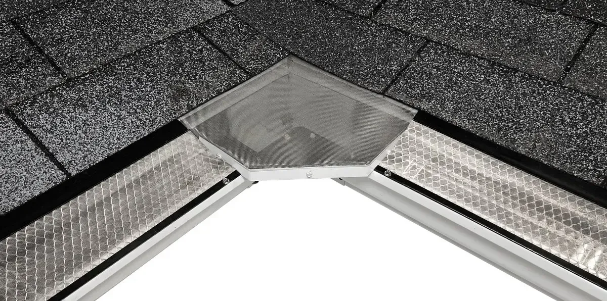 Corner of a roof with black shingles and a silver gutter.
