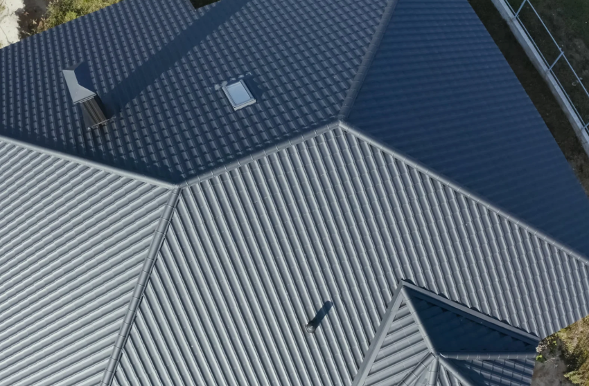 Overhead view of a house roof with a gray and dark blue metal finish.